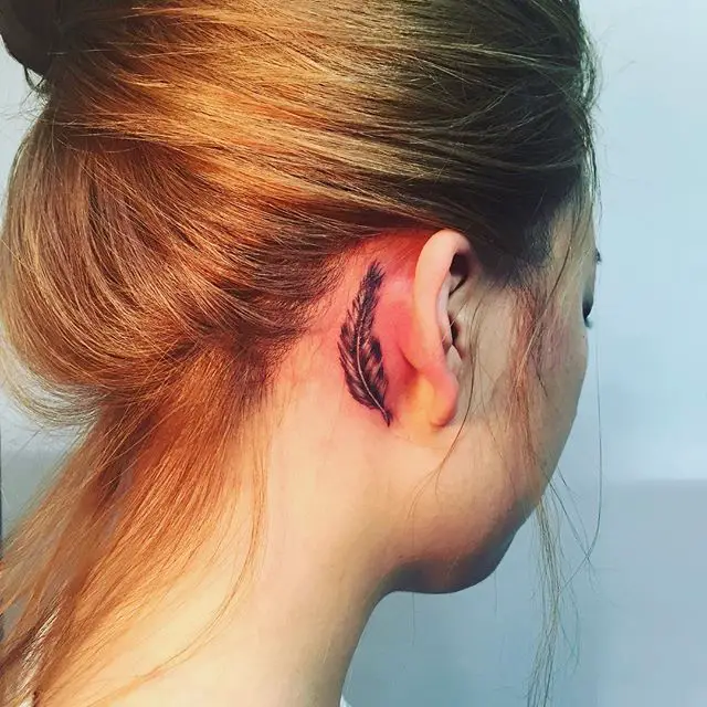 tatuagem atrás da orelha de pena