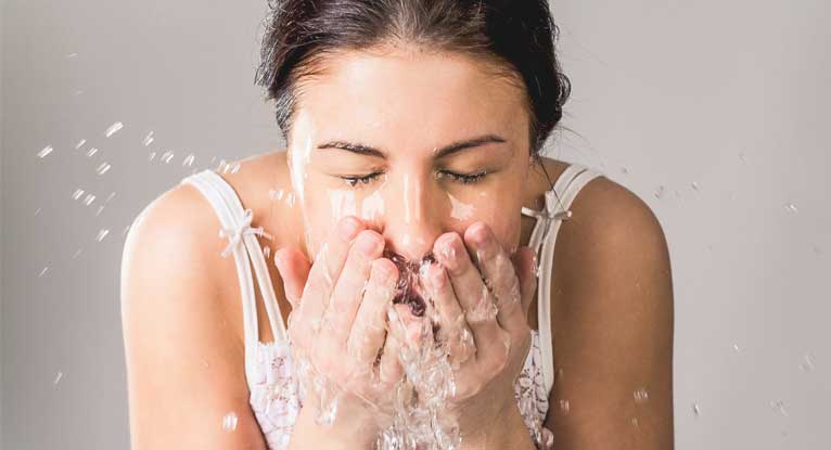 mulher lavando o rosto